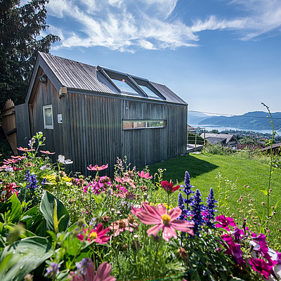 BIWAK ist unser exklusives Haus im Grünen, hoch oben über Seeboden, wo sich der Blick über majestätische Gipfel und glitzernden See reicht.